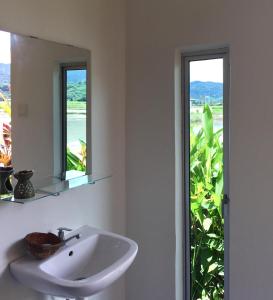 瓜埠Kawah Padi Garden Villa Langkawi的一间带水槽的浴室和两个窗户