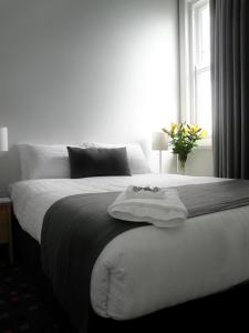 纽卡斯尔恩光酒馆酒店的卧室配有一张大白色床和窗户