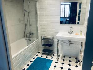 特雷吉耶B&B du Cloître的白色的浴室设有水槽、浴缸和水槽。