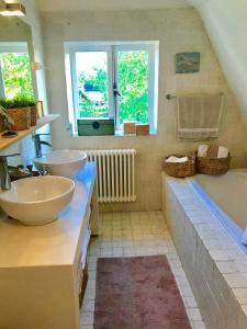 阿布考德Charming countryhouse near Amsterdam的浴室配有两个盥洗盆和浴缸。