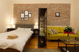 蒂米什瓦拉Stylish Flat in the Heart of Historical Center的一间卧室配有一张床和一张黄色的沙发