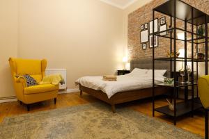 蒂米什瓦拉Stylish Flat in the Heart of Historical Center的一间卧室配有一张床和一张黄色椅子