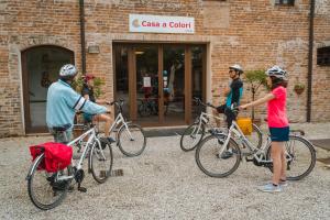 多洛Hotel Casa a Colori Venezia的一群人站在大楼外,骑着自行车