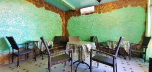 阿德勒Домовладение Mark Inn的配有桌椅和绿色墙壁的客房