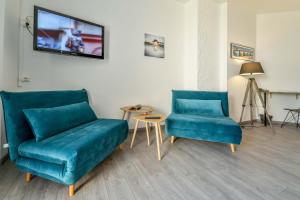 GanLogis Hostellerie du Neez的客厅配有2把蓝色椅子和电视
