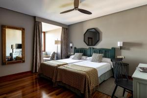 宏达瑞比亚宏达瑞比亚旅馆的一间卧室配有两张床和镜子