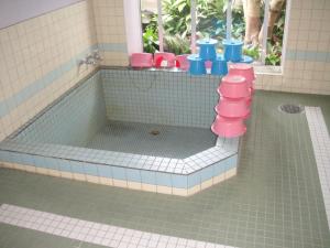 滨松马特斯舒酒店的浴室设有玩具浴缸,配有粉色和蓝色的厕所
