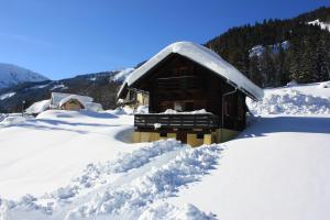 Radmer an der HaselBlockhütte Radmer的雪覆盖的小屋,有一堆积雪