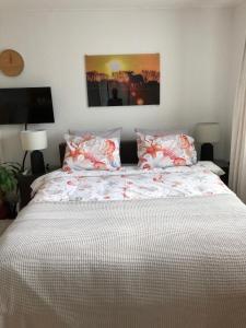 德科赫De vier Berken 1的卧室配有一张大床,提供红白床单和枕头。