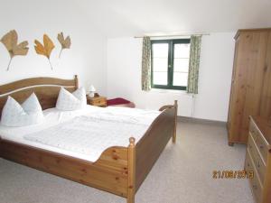 乌埃克尔明德克莱恩旅馆的一间卧室设有一张木床和一个窗户。