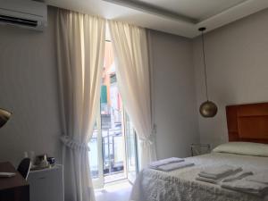 那不勒斯“A piazzetta”的一间卧室设有一张床和一个大窗户