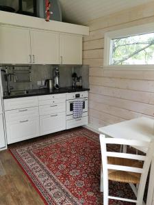 Järpen25 kvadrat 25 minuter från Åre的厨房配有白色橱柜和红色地毯