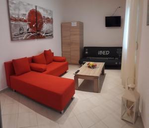 艾斯普罗瓦塔Elena Rooms-Apartments的客厅配有红色沙发和茶几