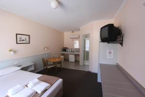 天鹅山拉兹河汽车旅馆的一间酒店客房,配有一张床和一台电视