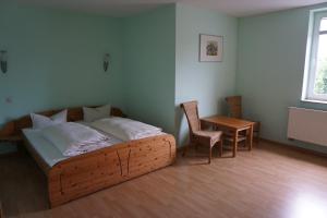 瓦伦Hotel am Bahnhof的卧室配有1张床、1张桌子和1把椅子