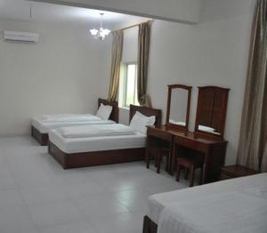苏尔阿尔萨库拉维公寓式酒店的酒店客房配有两张床和一张书桌