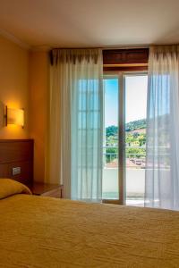 奥伦塞马布酒店的一间卧室设有一张床和一个大窗户