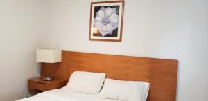 尼亚加拉瀑布Niagara Inn的一张带木制床头板的床和墙上的照片