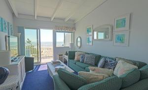 Amagansett克里斯特海酒店的客厅设有绿色沙发和阳台。