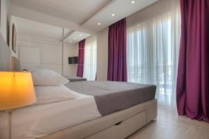 斯韦蒂·斯特凡Guest House Pržno Bay的一间卧室配有一张大床和紫色窗帘