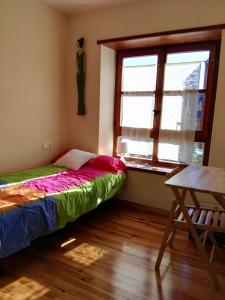埃斯特里-德阿内乌Soleado En Esterri的一间卧室设有一张床、一个窗口和一张桌子