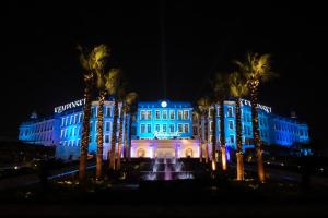 开罗开罗凯宾斯基御美心皇宫酒店的一座建筑,在晚上前方有一个喷泉