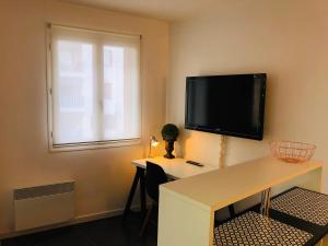 尼斯Nice Promenade 1的客房设有书桌和壁挂式平面电视。