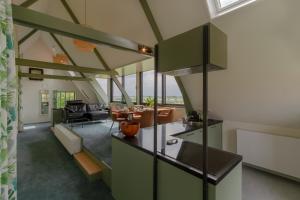 ElstB&B Weids的开放式厨房和带绿色橱柜的客厅。