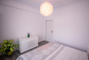 北马马亚-讷沃达里Nairi Apartment的白色卧室配有一张床和一个吊灯