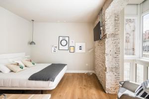 布尔戈斯APARTAMENTOS ELEVEN ROOMS的一间卧室设有一张床和砖墙