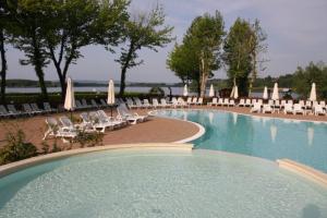 Candia Canavese安萨勒斯世界度假酒店的一个带椅子和遮阳伞的大型游泳池