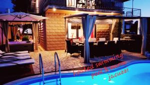 马林斯卡Villa Summer dream with heated pool, sauna and jacuzzi的一座带餐厅的房子前的游泳池