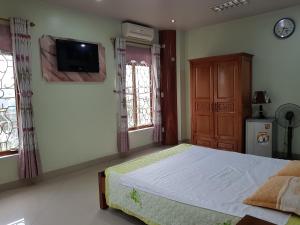 Phủ LýKhách sạn Anh Đào的卧室配有一张床,墙上配有电视。
