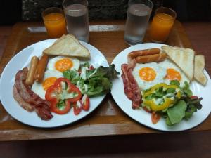 七岩Anyamanee Resort的两盘早餐食品,包括鸡蛋培根和沙拉