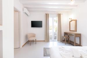 瓦里Syros village suites的白色的客厅配有床和电视