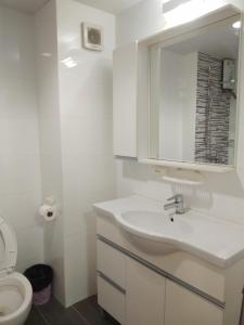梅尔皮姆Grandbeach2 B52 By malai的白色的浴室设有水槽和卫生间。