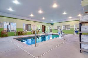 麦库克Quality Inn & Suites的游泳池,位于带绿色墙壁的房间
