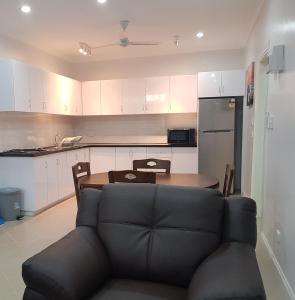 霍尼亚拉Prestige Apartments - Solomon Islands的客厅配有沙发和餐桌,厨房配有桌子
