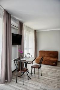 伊万诺-弗兰科夫斯克Apart Reserve Sloboda Loft的客厅配有桌椅和沙发