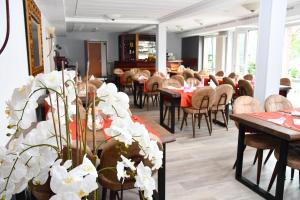 LengedeLANDHAUS LENGEDE Hotel的用餐室配有桌椅和白色鲜花