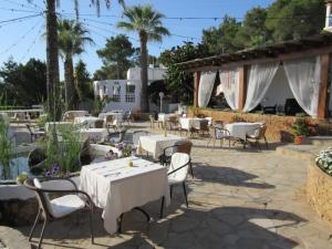 卡拉林亚俱乐部坎霍尔迪酒店的庭院配有白色桌椅,棕榈树