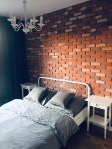 格但斯克Lofty & Apartamenty Garnizon Gdańsk的一间卧室设有砖墙和一张床