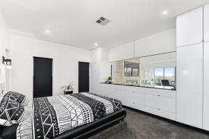 芒特甘比尔KENNEDY EXECUTIVE TOWNHOUSE的白色的卧室设有黑白色的床和水槽