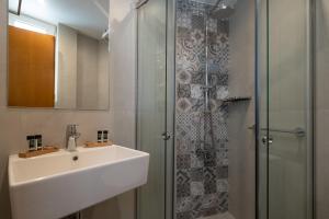 雅典卫城景色酒店的一间带水槽和淋浴的浴室
