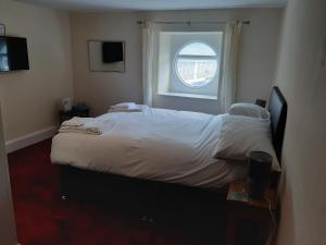 利德尼The Swan Hotel的一间卧室设有一张大床和窗户