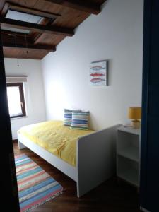 巴勒莫Casa PAN (Percorso Arabo Normanno)的一间卧室配有一张带黄色床单的床和一扇窗户。