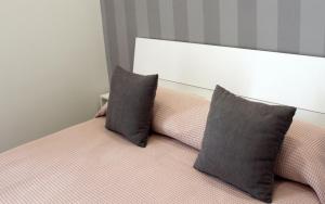 庞贝Magma centotre Pompei的一张带两个灰色枕头的床