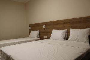 巴统32精品酒店的配有2张床的带白色床单和枕头的客房
