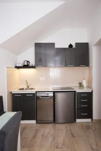 斯普利特Old Town Apartment Split的厨房配有黑色橱柜和不锈钢洗碗机。