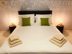 蒙泰卢波菲奥伦蒂诺House of Arts的卧室配有带绿色枕头的大型白色床